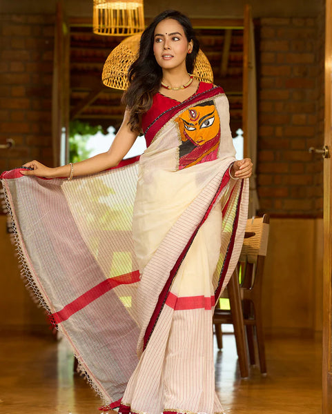 White cotton saree with bold red-black borders, featuring a hand-painted Durga motif