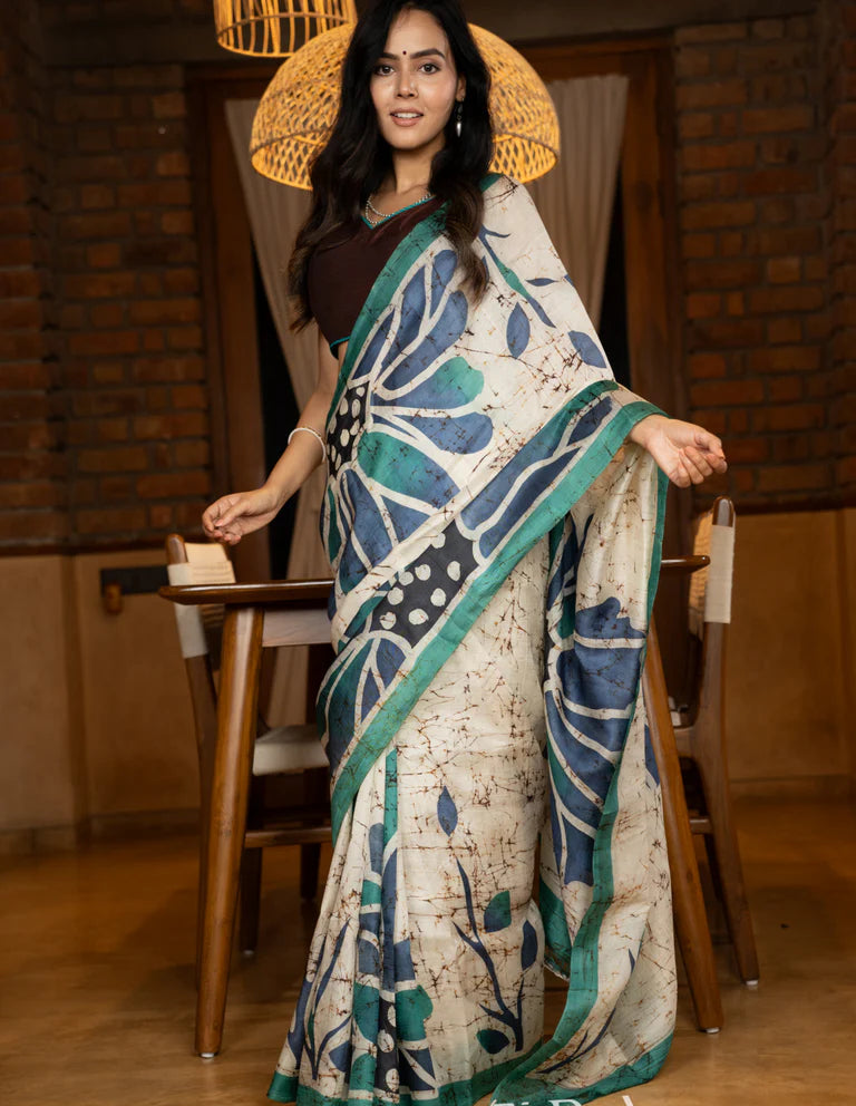 Classic Ivory pure silk saree highlighted by teal borders and hand batik artistry