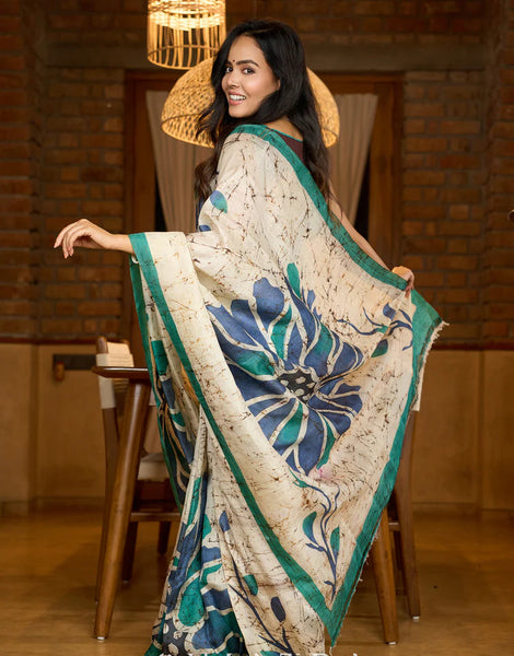 Classic Ivory pure silk saree highlighted by teal borders and hand batik artistry
