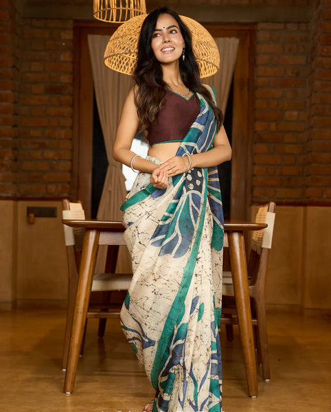 Classic Ivory pure silk saree highlighted by teal borders and hand batik artistry