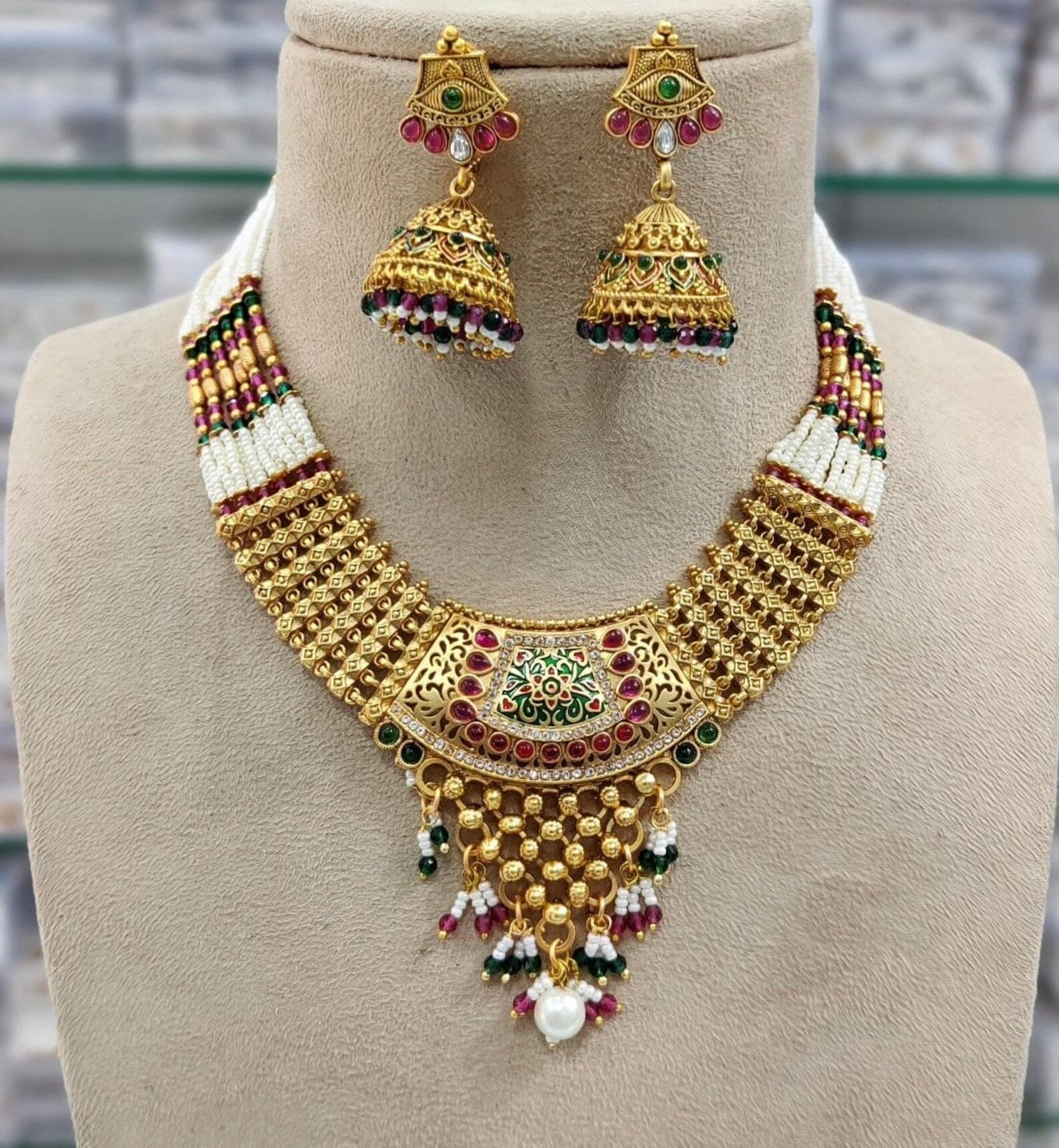 Gold plated necklace set with red green stones and meenakari