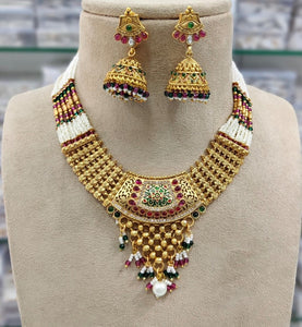 Gold plated necklace set with red green stones and meenakari