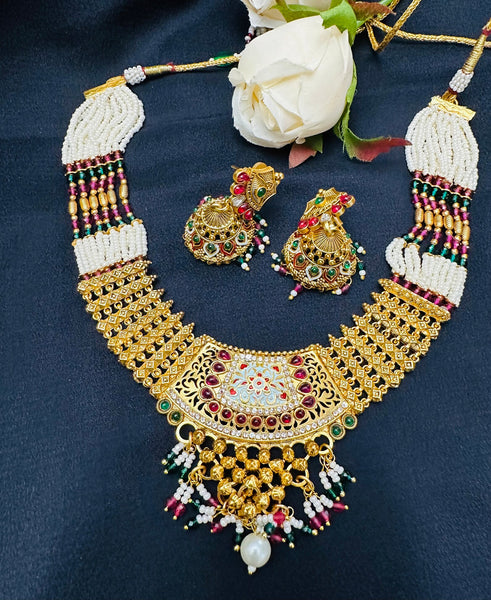 Gold plated necklace set with red green stones and meenakari